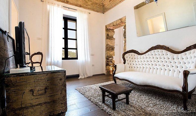 Οι λευκοί δερμάτινοι καναπέδες Λουδοβίκου ΧΙV που δεσπόζουν στο lounge του ξενώνα