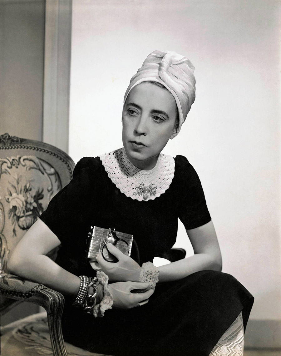 Η σχεδιάστρια Elsa Schiaparelli φορώντας μαύρο μεταξωτό φόρεμα με κροσέ γιακά δικό της σχέδιο και τουρμπάνι, φωτογραφία του Fredrich Baker, Vogue, 1940 © Condé Nast μέσω Getty Images