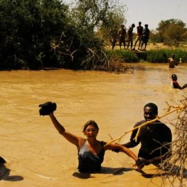 Η φωτογράφος Lynsey Addario κρατά την κάμερά της για να μη βραχεί κατά τη διάρκεια αποστολής στο νότιο Σουδάν, 2004