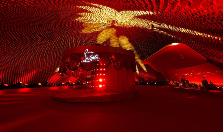 Η σκηνή είχε καλυφθεί εξ ολοκλήρου με ανακλασικό υλικό δημιουργώντας μία οπτική ψευδαίσθηση των κόκκινης σόλας, το έμβλημα του οίκου